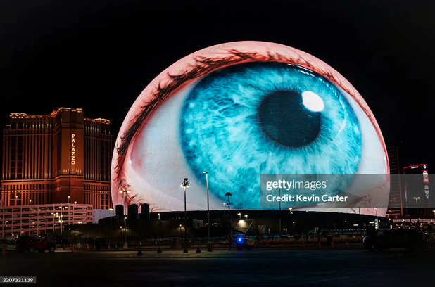 Photo of the Sphere in Los Vegas. It's a massive spherical building that can act as a screen. In this photo, it looks like a giant eyeball.