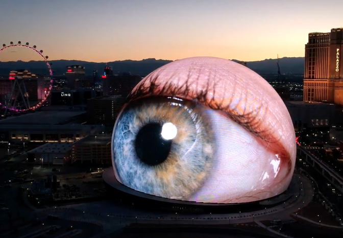 Photo of the Sphere in Los Vegas. It's a massive spherical building that can act as a screen. In this photo, it looks like a giant eyeball.
